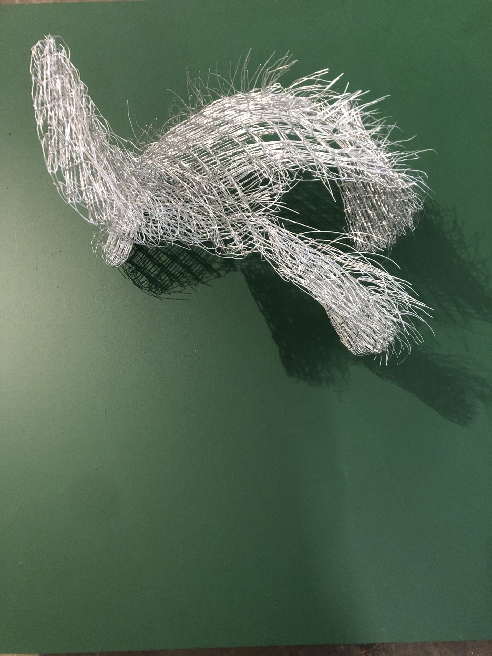 steel wire sculpture on green background. by artists Emilia Elfvik and Sara Wallstedt.